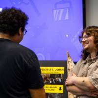 Film Student talking to event attendee at his booth